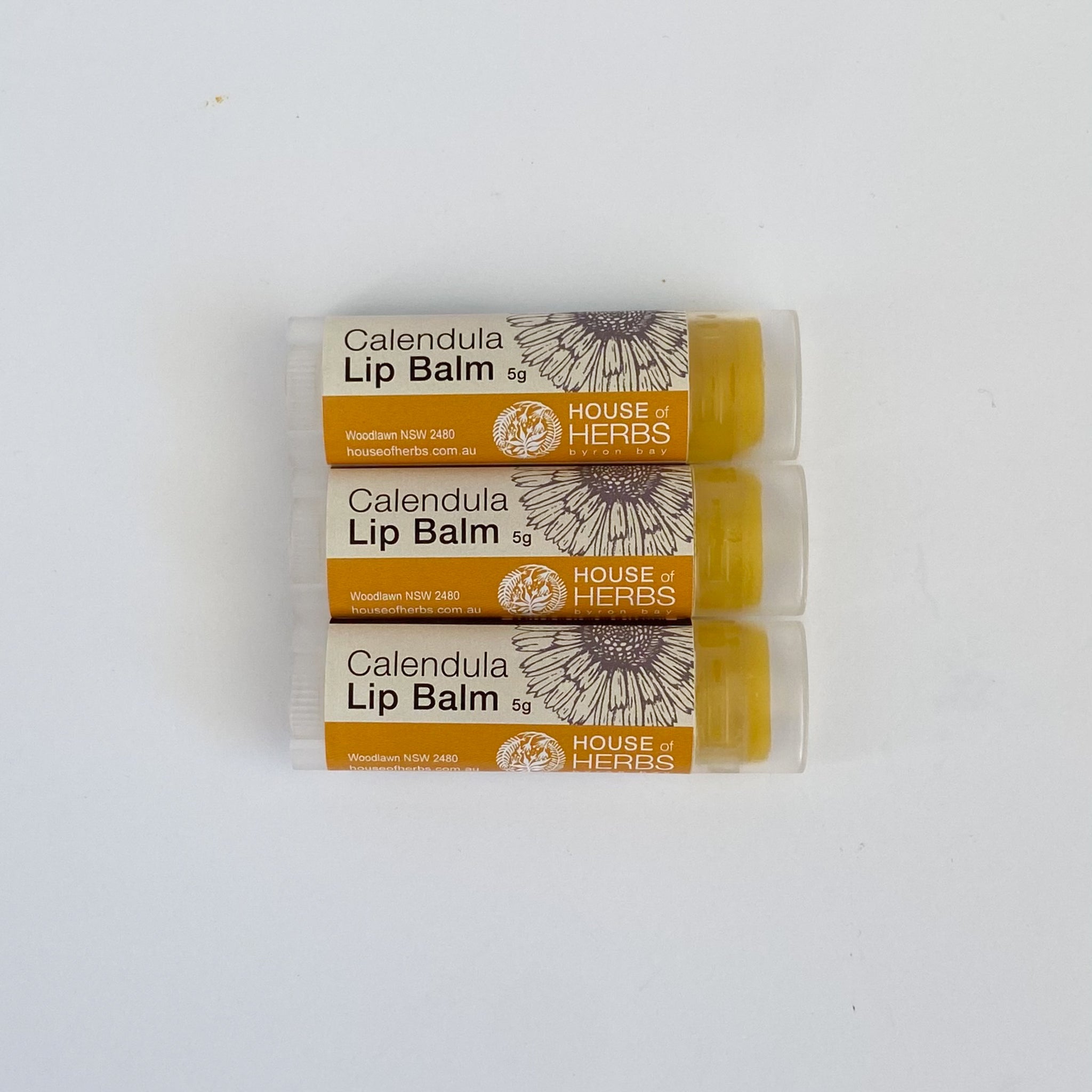 Three tubes of Calendula Lip Balm from House of Herbs on a white background