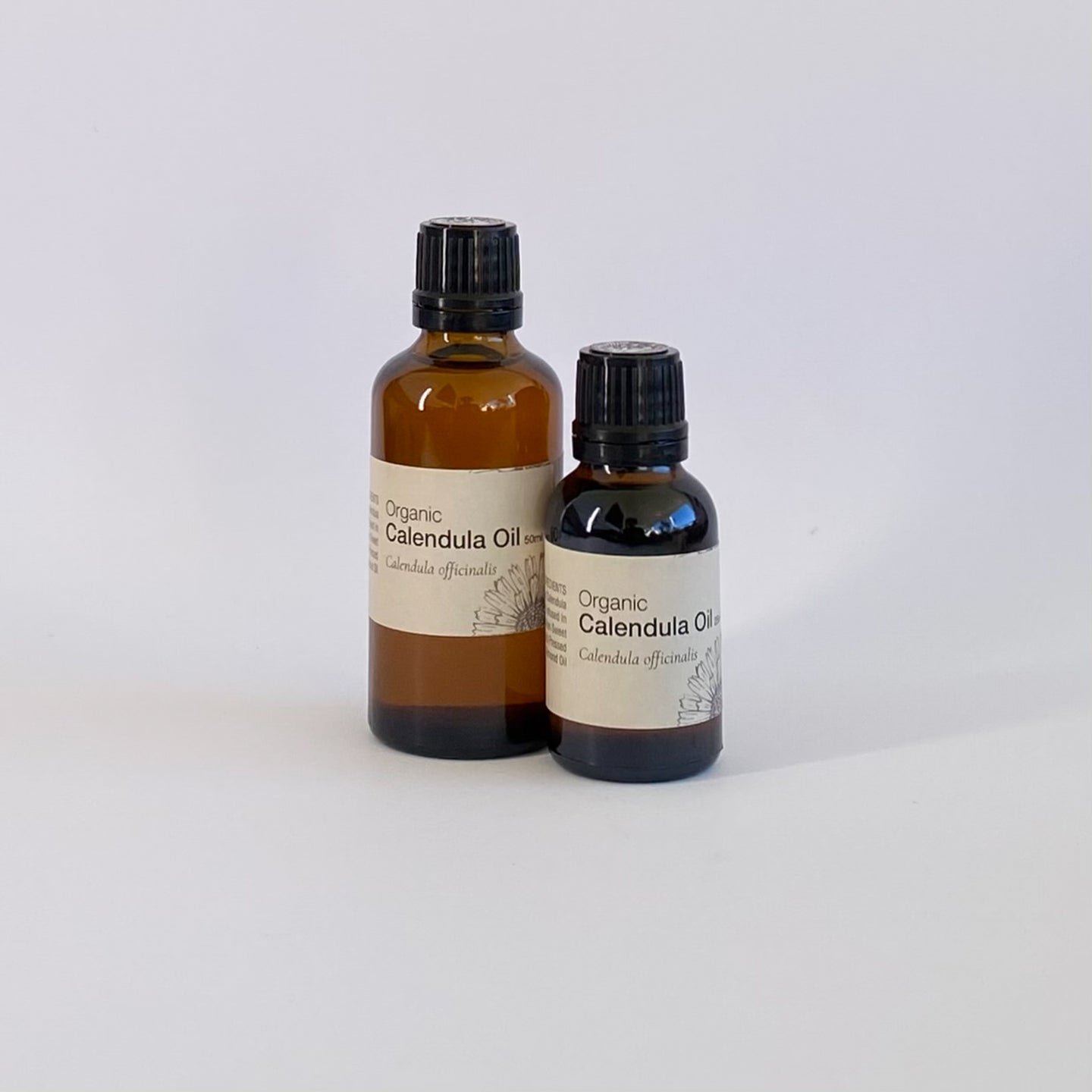 Two bottles of Organic Calendula Oil on a white background