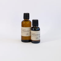 Two bottles of organic chamomile oil on a white background