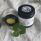 two jars of Healing Herbal balm on a linen background with gotu kola