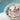 Bowl of bath salts with flowers and petals on a blurred natural background