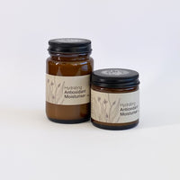 Two jars of hydrating antioxidant moisturizer on a white background