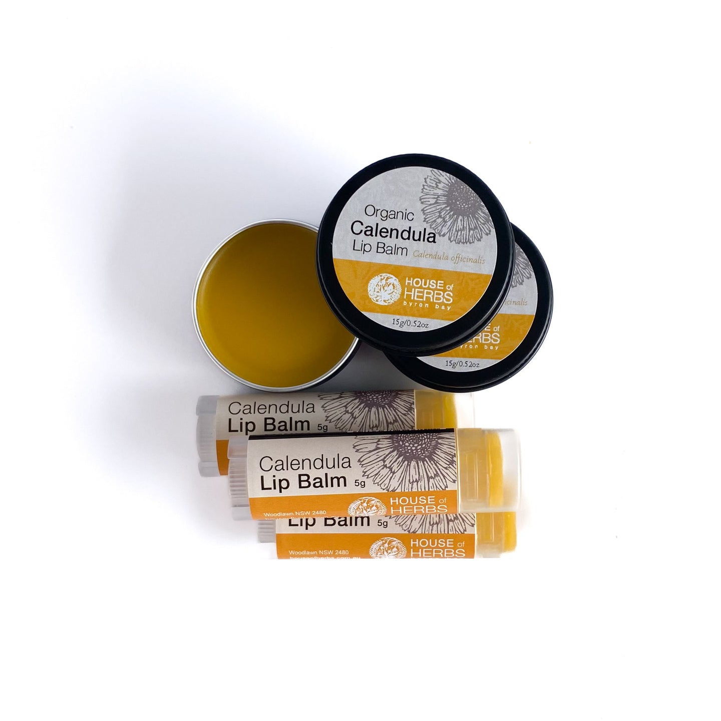 Calendula lip balm packaging including a tin and stick on a white background
